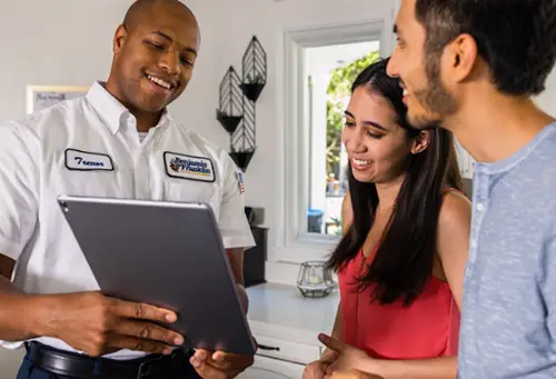 Benjamin Franklin Plumbing Tech, Trevor, speaking with homeowners at their home in Miami FL